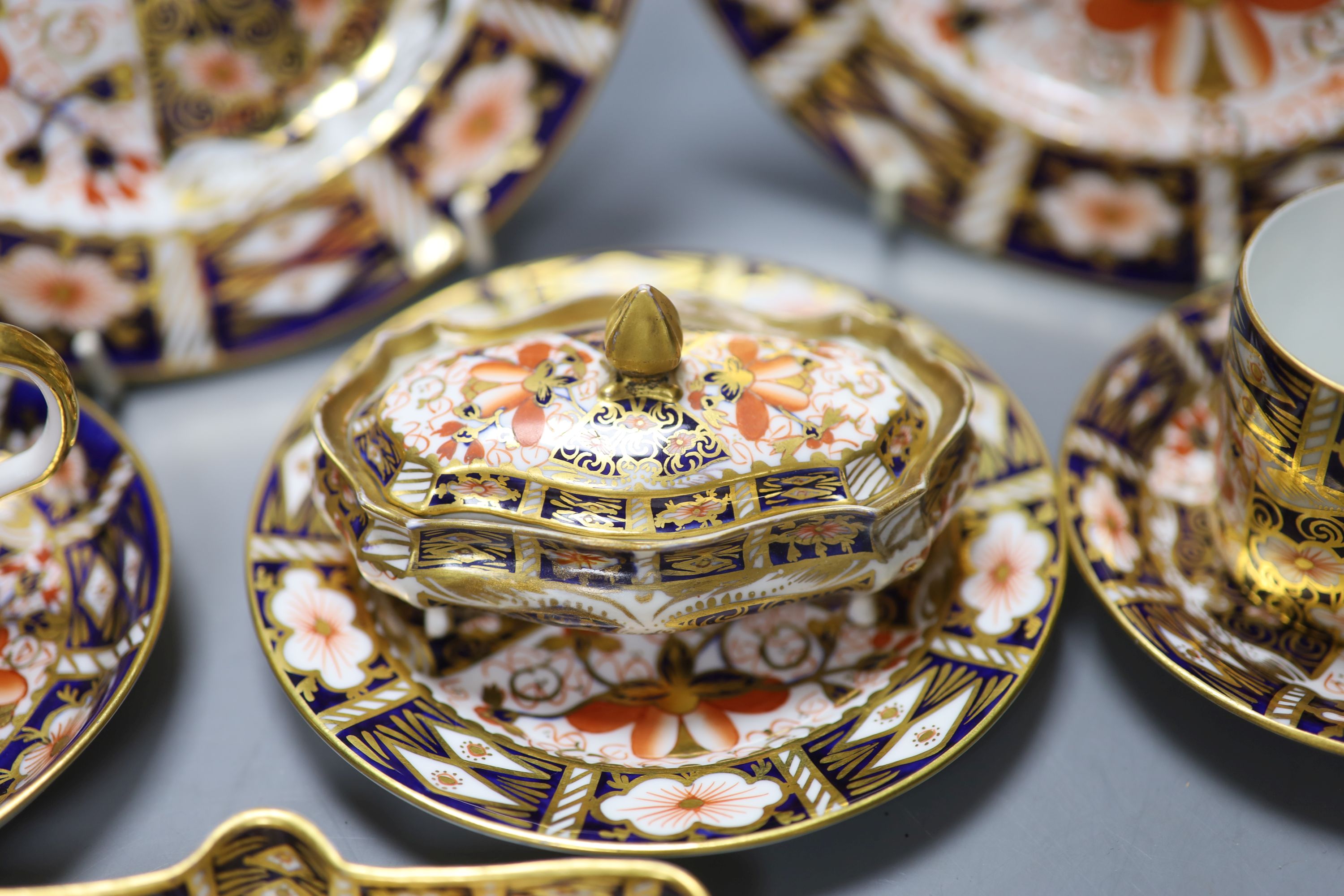 A Royal Crown Derby imari pattern 2451 cup and saucer, three cans and saucers, two bread plates, a small plate, a fan shaped dish and a